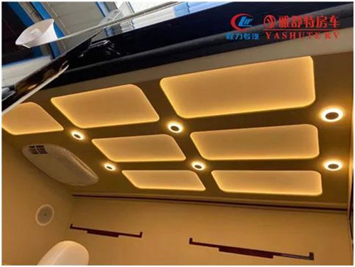 內(nèi)部車頂：采用帶造型的正白 LED 燈箱作為主照明系統(tǒng)，四角設(shè)計有帶獨(dú)立開關(guān)的裝飾射燈，嵌入式裝配工藝，便于后期檢修維護(hù)。車內(nèi)照明系統(tǒng)偏向于簡潔、實(shí)用、明亮、整齊的現(xiàn)代辦公氛圍，LED 射燈指向光源和立柱壁燈，對整個辦公區(qū)照明，整車 內(nèi)部氛圍襯托均予以兼